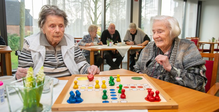 Zwei Frauen im besten Alter spielen fröhlich das Brettspiel Mensch Ärger dich nicht.