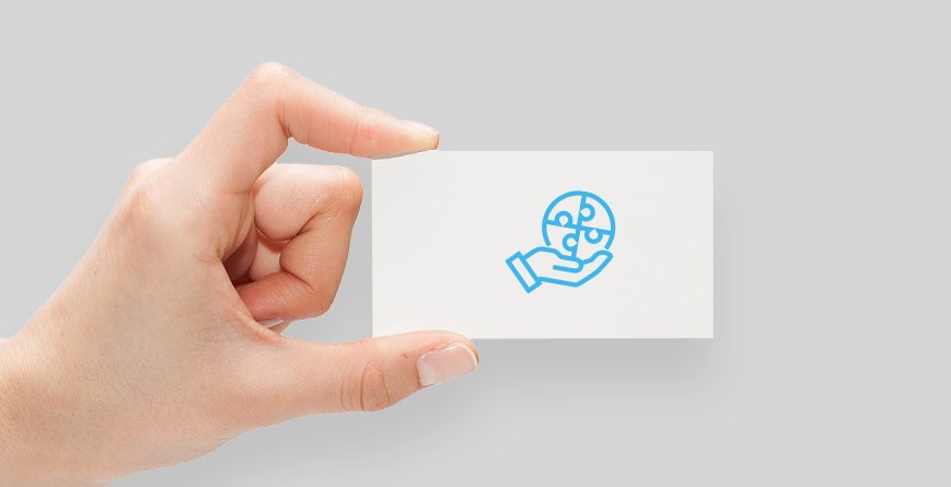 Eine Hand hält eine Karte mit einem Icon. Darauf abgebildet ist eine stilisierte Hand, die ein rundes Puzzle aus 4 zusammengefügten Teilen hält.